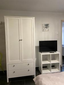 - une chambre avec une armoire blanche et une télévision dans l'établissement SenoRita, à Miskolc