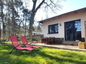 two chairs sitting in the grass in front of a house at Apartment Waldblick vom Naturhof Usedom in Bannemin