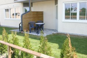 een patio met 2 stoelen en een tafel in de tuin bij Volontärgatan - Visby Lägenhetshotell in Visby