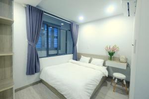 Postel nebo postele na pokoji v ubytování Dlux Saigon