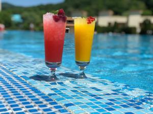 two cocktails are sitting on a swimming pool at Aquamarine Hotel&Spa in Plyakho