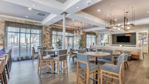 a restaurant with tables and chairs and a bar at Staybridge Suites Savannah Historic District, an IHG Hotel in Savannah