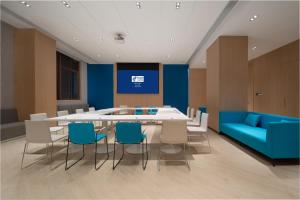 a conference room with a table and chairs and a blue couch at Holiday Inn Express Jinjiang Anhai by IHG in Jinjiang