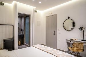 a bedroom with a bed and a mirror and a desk at Hippocampus Hotel in Kamari