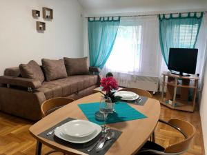 a living room with a table and a couch at BellaVista Apartmani in Stara Pazova