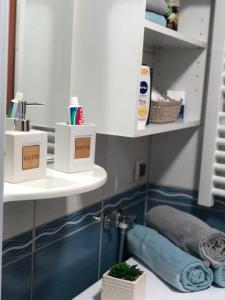 ein Badezimmer mit einem Waschbecken, einem Spiegel und Handtüchern in der Unterkunft BellaVista Apartmani in Stara Pazova