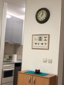 a kitchen with a clock on the wall and a wooden cabinet at BellaVista Apartmani in Stara Pazova