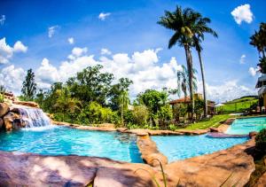 a large pool with a waterfall and a waterfall slide at Hotel Fazenda Horizonte Belo in Brumadinho +81 photos