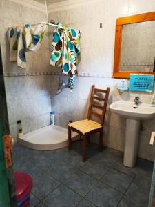 La salle de bains est pourvue d'une baignoire, d'un lavabo et d'une chaise. dans l'établissement Hostel Tenerife, à La Orotava