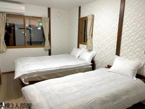 A bed or beds in a room at 富士晴 Guest House