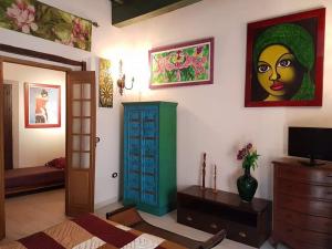 a living room with a green cabinet and a painting on the wall at Pensión Alfin in Granada
