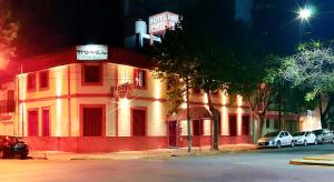 a building with cars parked in front of it at Hotel Paris in General San Martín