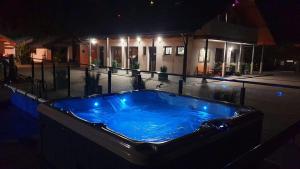 a large blue hot tub in front of a house at night at Jastrzębia Port in Jastrzębia Góra