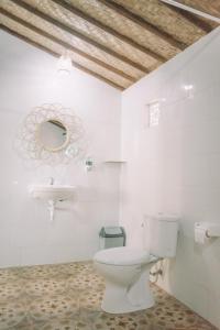 a bathroom with a toilet and a sink at Mertasari Bungalows in Nusa Penida