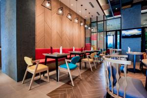 a restaurant with tables and chairs in a room at ibis Styles Kota Bharu in Kota Bharu