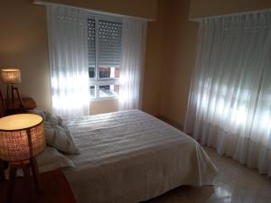 a bedroom with a white bed and a window at Departamento Necochea in Necochea