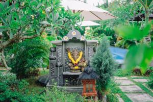 un jardin avec une statue au milieu dans l'établissement Mertasari Bungalows, à Nusa Penida