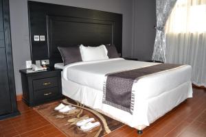 1 dormitorio con 1 cama grande y cabecero negro en Panone Hotels - King'ori Kilimanjaro Airport en Moshi