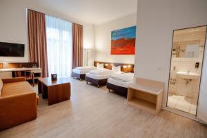 a hotel room with two beds and a bathroom at Hotel Tiergarten Berlin in Berlin