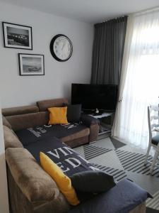 sala de estar con sofá y TV en Apartament szafirowa25 pietro1, en Kołobrzeg
