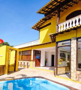 Villa con piscina frente a una casa en Pousada Gente Bonita João Fernandes, en Búzios