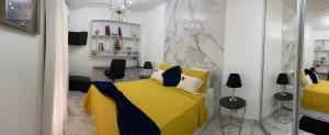 um quarto com uma cama amarela e 2 cadeiras em Charme Comforto Beira Mar em Angra dos Reis
