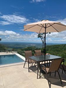 沙帕達－杜斯吉馬朗伊斯的住宿－Paraíso do Morro dos Ventos，游泳池旁带遮阳伞的桌子