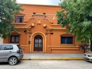 a orange building with a car parked in front of it at Donna Alda Casa in Salta