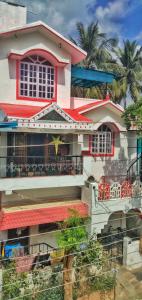een rood-wit huis met een balkon bij Criston Home stay in Madurai