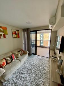 uma sala de estar com um sofá e uma grande janela em Landscape Beira Mar Meireles em Fortaleza