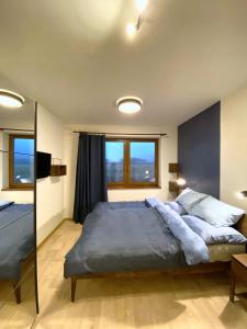 a bedroom with a large bed and a large window at Panorama Home Valča in Valča