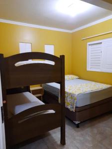プライア・ド・フランセスにあるCantinho da Felicidadeの黄色い壁の客室で、二段ベッド2組が備わります。