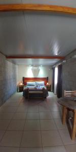 Habitación grande con cama y mesa. en Nelumbo Petit Chalet en San Rafael