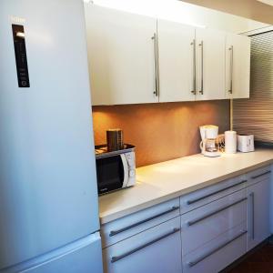 a kitchen with white cabinets and a microwave at U Riniccio in Sagone +6 photos