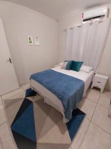- une chambre avec un lit doté d'une couverture bleue dans l'établissement Moradas Pará Satélite 303, à Belém