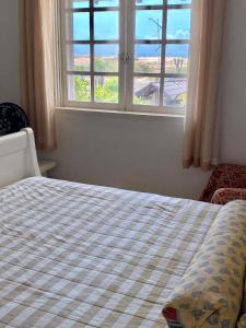 1 cama en un dormitorio con ventana en Casa Beira Mar, en Torres
