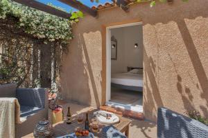 eine Außenterrasse mit einem Bett in einem Zimmer in der Unterkunft maison kiwi avec piscine chauffée terrasse jardin et bbq à Calvi in Calvi