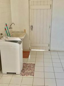 un bagno con una porta bianca e un frigorifero di Casa Beira Mar a Torres