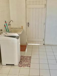 baño con puerta blanca y nevera en Casa Beira Mar, en Torres