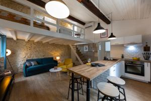a kitchen and living room with a blue couch and a table at Dolce NÎMES CENTRE in Nîmes