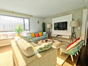 ein Wohnzimmer mit einem Sofa und einem TV in der Unterkunft Bom dia Parque Nações LisboaX in Lissabon