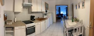 a kitchen with white cabinets and a counter top at KŐNIG APARTMAN III. in Hévíz