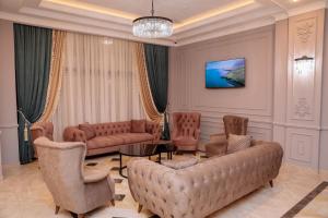 una sala de estar con sofás, sillas y una lámpara de araña. en Hotel Resident Bishkek, Отель Резидент Бишкек 2021Opening, en Bishkek