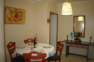 mesa de comedor con mantel y sillas blancas en Vila Marachique Mariosilvat, en Alvor