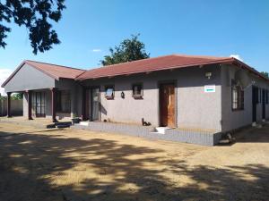 a small white building with a red roof at Coolden guesthouse in Vanderbijlpark