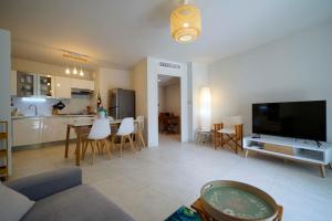 uma sala de estar com um sofá, uma televisão e uma cozinha em Spécial Golf Appartement de 2 à 4 pers Classé 4 étoiles em Saint-Raphaël