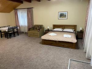 a bedroom with a bed and a chair and a table at Central Courtyard in Slavske +64 photos