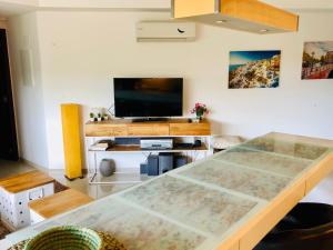 uma sala de estar com uma mesa e uma televisão em Apartamento Acapulco Roosevelt em Punta del Este