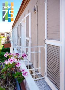 a building with stairs and flowers in front of it at Cadde 75 Luxury Hotel - Alaçatı in Alaçatı