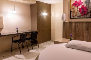 a hotel room with a bed and a desk at Fada Hotel - Motel Adults Only in Recife